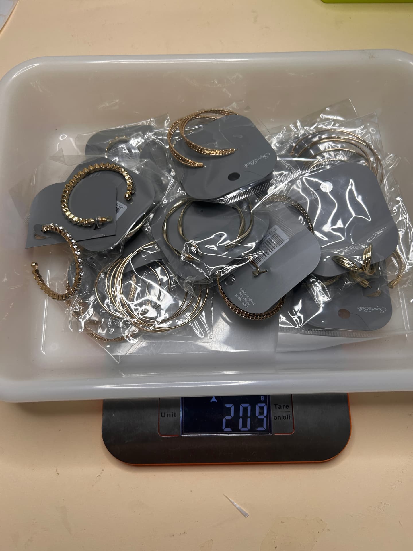Las 30 parejas de pendientes de aro dorados sobre una báscula, peso total 200 g